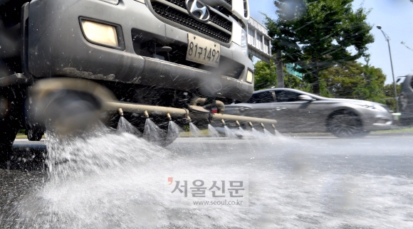 폭염주의보가 내린 4일 서울 송파구 올림픽공원 앞에서 살수차량이 도로위의 열기를 식히기 위해 물을 뿌리고 있다. 2019.7.4 박지환기자 popocar@seoul.co.kr