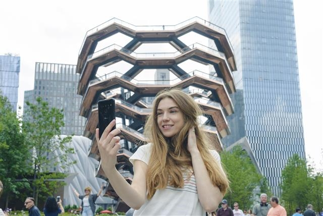 미국 뉴욕의 새 랜드마크 허드슨야드의 조형물 베슬을 배경으로 모델이 LG V50씽큐를 소개하고 있다. LG전자 제공