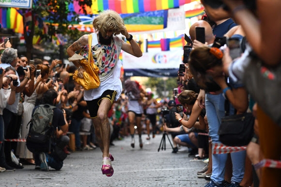 4일(현지시간) 스페인 마드리드 성소수자(LGBT) 커뮤니티에 인기 있는 지역인 추에카(Chueca)에서 ‘프라이드 하이힐 신고 달리기’가 열려 참가자가 힐을 신고 달리고 있다. AFP 연합뉴스