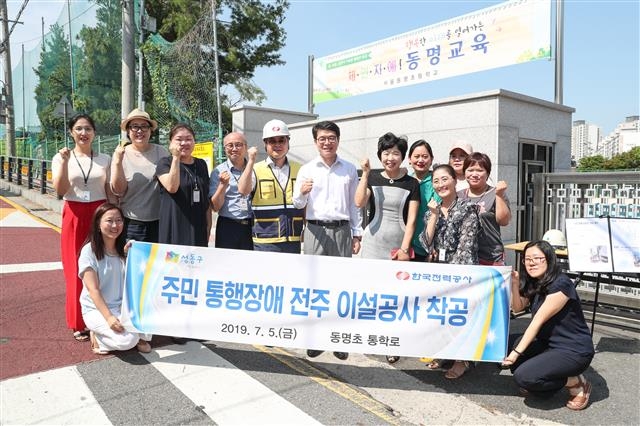 정원오(뒷줄 왼쪽 여섯 번째) 성동구청장이 지난 5일 오전 10시 동명초등학교 정문에서 열린 주민 통행 장애 ‘전주 이설 착공식’에 참석, 학부모, 한전 관계자 등과 기념촬영하고 있다. 성동구 제공