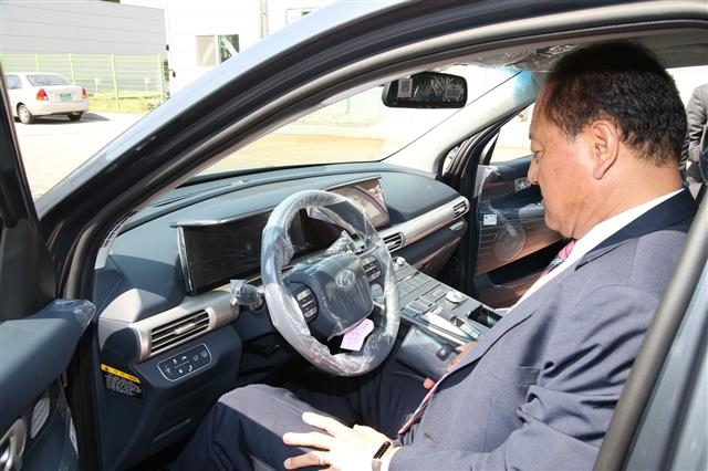 지난달 19일 서울 마포구 성산SH임대아파트 주차장에서 열린 전기자동차 시승식에서 유동균 마포구청장이 직접 수소차에 탑승해 보고 있다. 마포구 제공