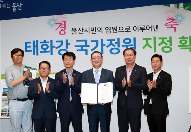 송철호(왼쪽 네 번째) 울산시장이 11일 울산시청 프레스센터에서 태화강 지방정원의 국가정원 지정을 환영하는 기자간담회를 연 뒤 직원들과 함께 인증서를 들고 포즈를 취하고 있다. 울산시 제공