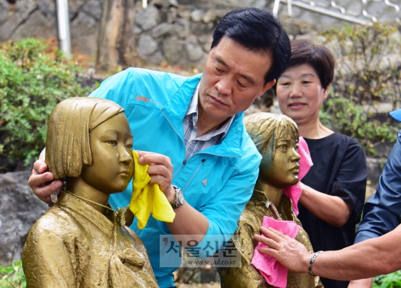 이승로 성북구청장이 지난 15일 지역 주민과 함께 동소문동 가로공원에 설치된 ‘평화의 소녀상’ 눈물을 닦아주고 있다. 이종원 선임기자 jongwon@seoul.co.kr