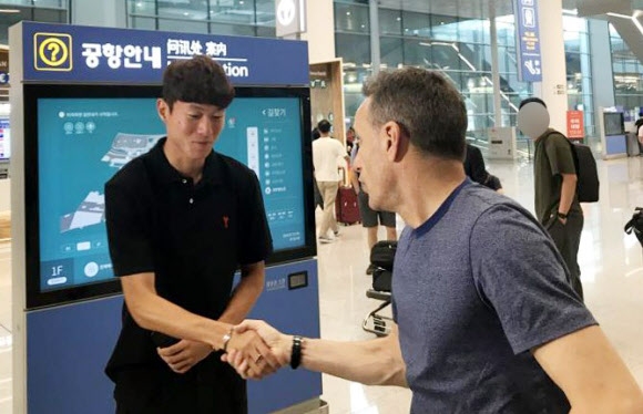 18일 프랑스 프로축구 지롱댕 보르도에 합류하기 위해 출국하는 황의조(왼쪽)가 인천국제공항에서 파울루 벤투 감독한테 축하인사를 받고 있다.  연합뉴스