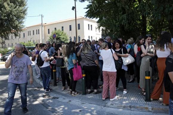 19일 그리스 수도 아테네를 강타한 규모 5.1의 강진으로 시민들이 건물 밖으로 나와 대피하고 있다.아테네 EPA 연합뉴스