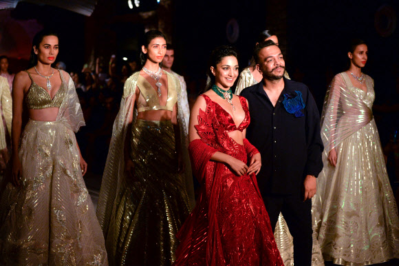 22일(현지시간) 인도 뉴델리에서 열린 ‘2019 FDCI 인디아 쿠튀르 위크(FDCI India Couture Week)’에서 모델들이 디자이너 아밋 아가월의 의상을 선보이고 있다.<br>AFP 연합뉴스