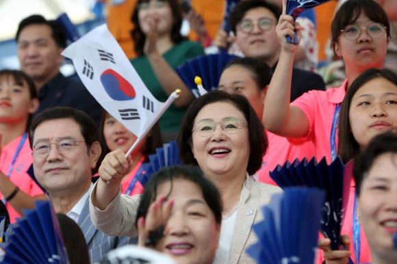 문재인 대통령 부인 김정숙(오른쪽) 여사가 23일 광주 남부대 수구경기장에서 열린 뉴질랜드와의 최종전에서 태극기를 흔들며 한국 남자 수구대표팀을 응원하고 있다. 김 여사 왼쪽은 이용섭 광주시장 겸 대회 조직위원장. 광주 연합뉴스