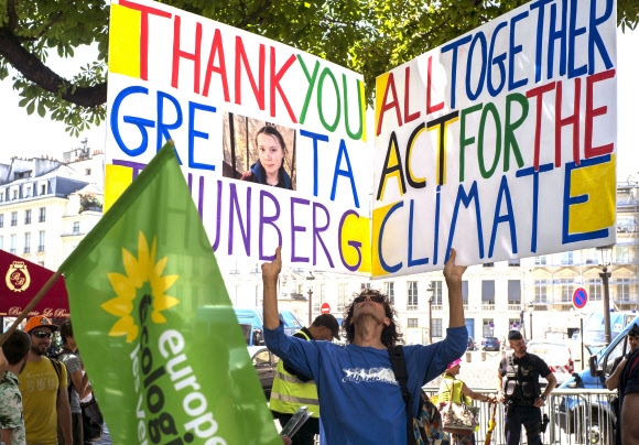 23일(현지시간) 환경 활동가 그레타 툰베리가 프랑스 의회에서 연설하는 동안 활동가들이 그에게 감사하다는 취지의 플래카드를 들고 서 있다. 파리 AP 연합뉴스
