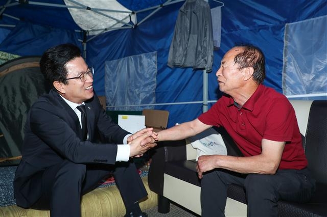 허태정(왼쪽) 대전시장이 지난달 12일 시청 북문에 천막을 치고 농성 중인 갑천지구 원주민을 만나 “주민 권리가 최대한 반영되도록 애쓰겠다”며 설득하고 있다.  대전시 제공