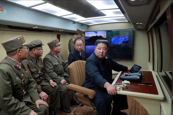 김정은 북한 국무위원장이 지난달 31일 군 관계자들과 원산 갈마에서 진행된 ‘신형 대구경조종방사포 시험사격’을 보고 있는 모습.  연합뉴스