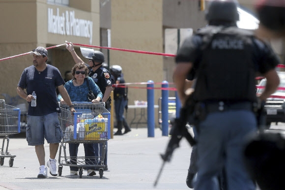 3일(현지시간) 미국 텍사스 주 엘 패소의 월마트에서 총기 난사 사건이 벌어져 20명이 숨지고 20여명이 다친 가운데 한 쇼핑객이 빠져나오고 있다. 2019.8.4  AP 연합뉴스