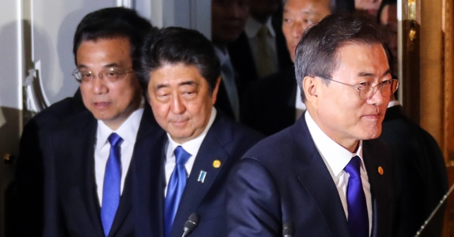 写真では、文在寅大統領（右から1人目）が昨年5月に東京で開催された第7回日中韓首脳会見の共同記者会見のホールに入る。 左から、日本の安倍晋三首相と中国の李克強首相。  2018.5.9聯合ニュース