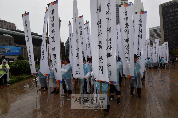 15일 서울 시청광장에서 열린 강제동원 공동행동주최 국제평화집회에 참석한 시민들이 깃발을 들고 행진을 하고 있다.  2019.8.15  박지환기자 popocar@seoul.co.kr