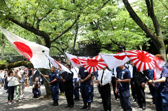日本の敗戦記念日であり、韓国からの解放の日である 15 日、東京の靖国神社で戦犯の旗である旭日旗を掲げている極右の男性たち。  2019.8.15 聯合ニュース