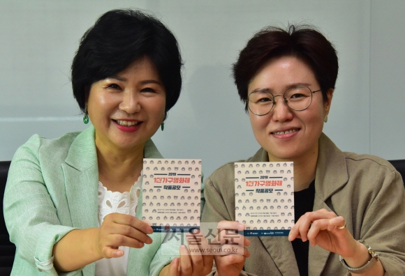 권금상(왼쪽) 서울시 건강가정지원센터장과 이지연 한국독립영화협회 사무국장이 오는 10월 18~19일 열리는 ‘1인 가구 영화제’ 홍보 카드를 들어 보이고 있다. 이종원 선임기자 jongwon@seoul.co.kr