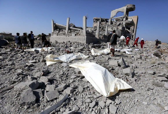 1일(현지시간) 사우디아라비아가 주도하는 연합군이 공습한 예멘 수도 사나 남쪽의 다마르의 후티 반군 감금시설이 처참히 부서진 가운데 시신들이 흰 천으로 덮여 있다. 국제적십자위원회는 이날 폭격으로 최소 100명이 사망했다고 추산했다. 다마르 EPA 연합뉴스