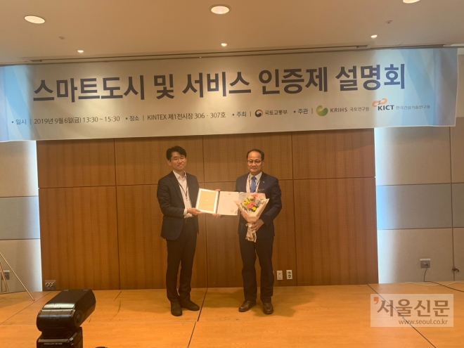 부천시 오동택(오른쪽) 스마트시티담당관이 국토교통부로부터 스마트도시 시범인증서를 받은 뒤 꽃다발을 들고 기념사진을 찍고 있다. 부천시 제공 