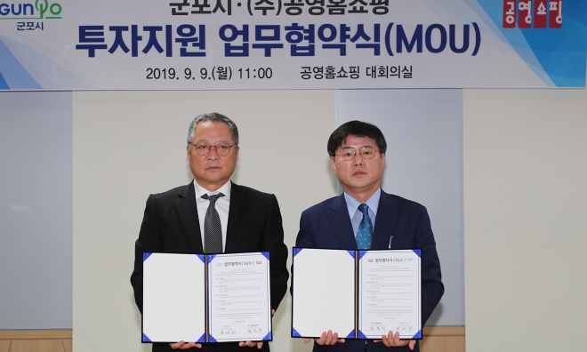 군포시 한대희(오른쪽) 시장이 최창희 대표이사와 ㈜공영홈쇼핑 투자 지원 업무협약을 체결하고 있다. 군포시 제공 