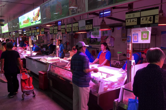 지난 11일(현지시간) 중국 베이징 시내 한 시장의 정육점을 찾은 고객들이 순서를 기다리고 있다. 베이징 AP 연합뉴스 