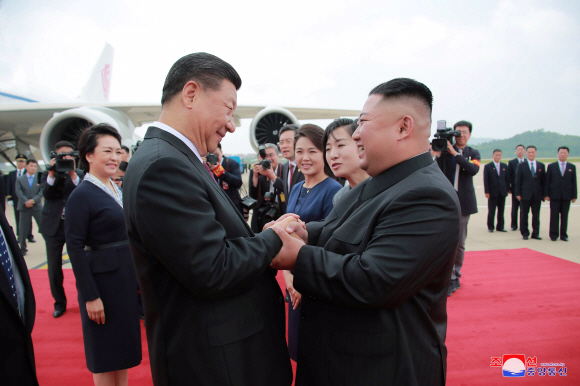 김정은(오른쪽) 북한 국무위원장이 지난 6월 21일 평양 순안공항에서 북한을 방문한 시진핑 국가주석을 맞아 악수하고 있는 모습. 조선중앙통신