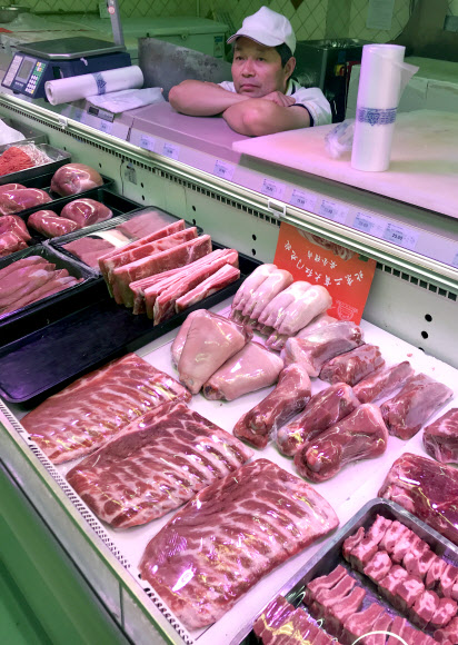 중국에서 아프라카돼지열병에 따른 공급 부족으로 돼지고기값이 급등하는 가운데 지난 22일 베이징의 한 슈퍼마켓 돼지고기 코너에서 판매원이 턱을 괸 채 손님을 기다리고 있다. 베이징 UPI 연합뉴스