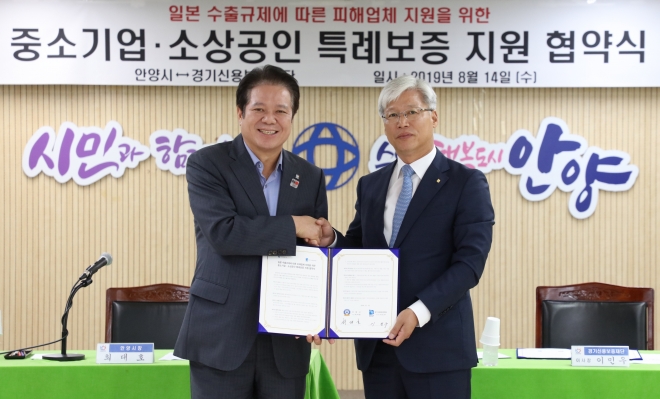 이민우 경기신용보증재단 이사장(오른쪽)과 최대호 안양시장이 지난 8월 14일 일본 수출규제로 피해를 입는 기업을 위한 특례보증 지원협약을 체결한후 기념 촬영을 하고 있다. 경기신용보증재단 제공 