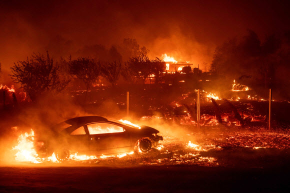 지난해 대형산불이 발생한 미국 캘리포니아주 북부 뷰트카운티의 파라다이스 지역에서 차량과 주택들이 화염에 휩싸여 있다. 연합뉴스