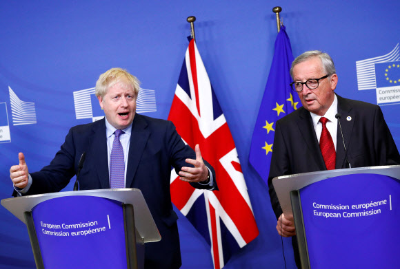 보리스 존슨(왼쪽) 영국 총리가 17일(현지시간) 벨기에 브뤼셀에서 열린 기자회견에서 브렉시트 합의안에 대해 설명하고 있다. 오른쪽은 유럽연합 행정부 수반 격인 장클로드 융커 집행위원장. 브뤼셀 로이터 연합뉴스