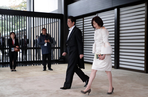 22일 일본 도쿄 지요다구 왕궁에서 열린 나루히토 일왕의 즉위의식에 아베 신조 일본 총리 부부가 입장하고 있다. 부인 아키에 여사는 다른 참석자들과 달리 무릎이 드러나 보이는 흰색 원피스 정장을 입었다. 도쿄 AFP 연합뉴스