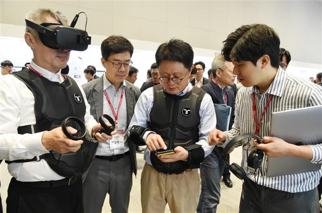 지난달 서울 강서구 마곡 LG사이언스파크에서 열린 ‘LG스타트업 테크 페어’에서 안승권(오른쪽 두 번째부터) LG사이언스파크 대표, 박일평 LG전자 CTO, 장영승 서울산업진흥원 대표가 ‘비햅틱스’의 제품을 체험해 보고 있다. LG그룹 제공