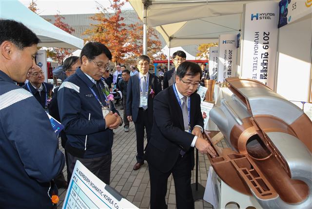 안동일(왼쪽 두 번째) 현대제철 사장이 지난 23일 당진제철소에서 열린 ‘제4회 현대제철 기술박람회’에서 기계 부품 제조사 코마틱코리아의 전시품을 관람하고 있다.  현대제철 제공