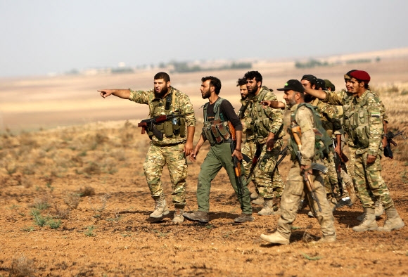 터키가 지원하는 시리아 민병대 대원들이 28일(현지시간) 시리아 북동부 라스 알아인 동쪽에서 쿠르드족 전사들이 주축을 이루는 시리아민주군(SDF)과 교전하기 위한 진지 구축을 상의하고 있다.라스 알아인 AFP 연합뉴스