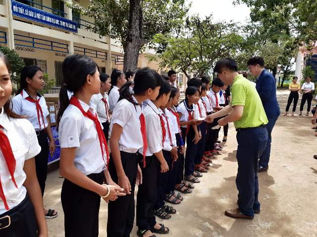 최규택 글로벌프랜드 대표와 곽인식 IBK기업은행 호찌민 지점장이 베트남 닥락성 부온마트온에서 60km 떨어진 보티사우 중학교 학생들에게 장학금을 나눠주고 있다. 글로벌프랜드 제공