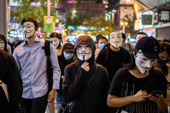 홍콩의 반정부 시위대가 5일(현지시간) 영화 ‘브이 포 벤데타’에 등장해 저항의 상징이 된 ‘가이 포크스’ 가면을 쓴 채 거리를 행진하고 있다.  AFP 연합뉴스