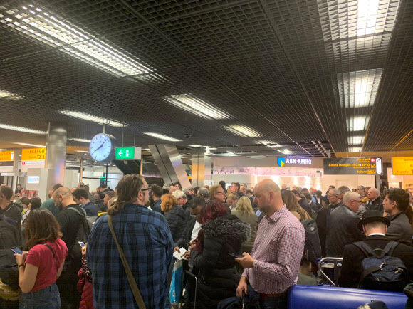 한 여객기 기장이 실수로 공중납치 경보를 누르는 바람에 항공기 이착륙이 대거 지연된 네덜란드 암스테르담 스히폴 국제공항의 D 터미널 안의 승객들이 영문을 모른 채 출발 대기줄에 서있다. 소셜미디어 로이터 연합뉴스