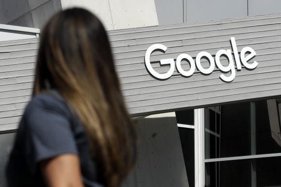 구글 본사인 미국 캘리포니아주 마운틴 뷰 캠퍼스의 구글 표지판 아래로 한 여성이 걸어가고 있다.  AP 연합뉴스