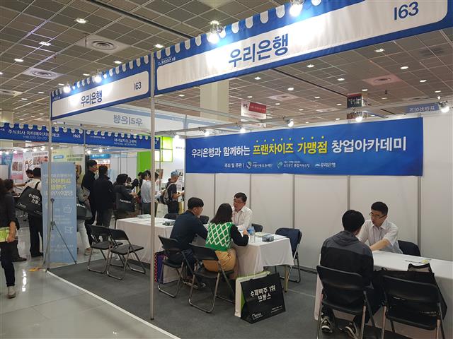 지난달 서울 삼성동 코엑스에서 열린 창업 박람회 ‘프랜차이즈서울’의 우리은행 부스에서 관람객이 금융 관련 상담을 받고 있다. 우리은행 제공