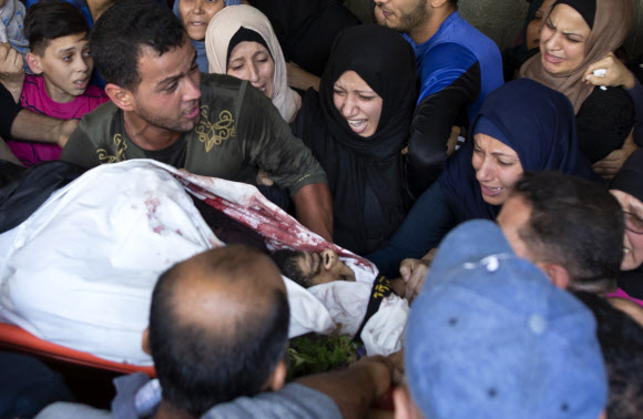 13일 아스라엘의 공습으로 사망한 팔레스타인 무장단체 ‘이슬라믹 지하드’ 대원 압둘라 알벨베시의 장례식에서 유족들이 슬퍼하고 있다. 가자지구 AP 연합뉴스