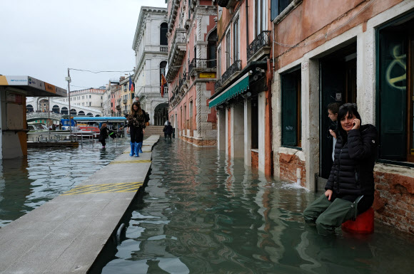 17일(현지시간) 이탈리아 베네치아가 침수되면서 주민들이 임시 다리를 통해 길을 지나고 있다. 베네치아 로이터 연합뉴스