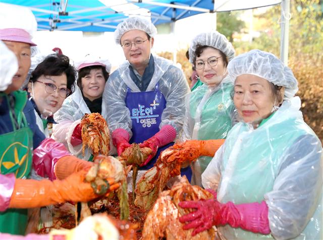 채현일(가운데) 서울 영등포구청장이 지난 15일 구청 광장과 당산공원에서 열린 ‘2019 사랑의 김장나누기 한마당’ 행사에 참여해 김장 김치를 담그며 포즈를 취하고 있다. 영등포구 제공