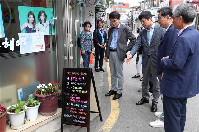 정원오(앞줄 왼쪽 첫 번째) 성동구청장이 ‘성동 원플러스원’ 사업 참여 미용실을 찾아 주민들과 얘기하고 있다. 성동구 제공