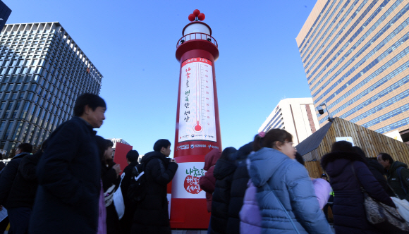 20일 서울 광화문광장에 설치된 사랑의온도탑 앞을 시민들이 걸어가고 있다.  2019. 11. 20 정연호 기자 tpgod@seoul.co.kr