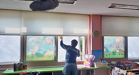 오투클린 대리점 지금디자인의 직원이 경기도 곡란초등학교 교실에 나노방진망을 시공하고 있다.