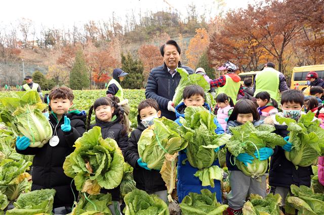 이성(뒷줄 가운데) 구로구청장이 지난 25일 구로구 오류IC 인근에 위치한 자연학습장에서 유치원 아이들과 함께 직접 수확한 배추를 들고 기념촬영을 하고 있다. 구로구 제공