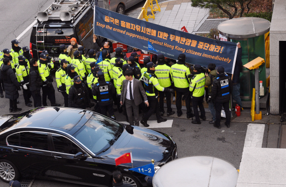 왕이 중국 외교담당 국무위원 겸 외교부장이 탄 차량이 강경화 외교부 장관과의 회담을 위해 4일 오후 서울 종로구 외교부 청사로 들어서고있는 가운데 중국의 홍콩 탄압을 규탄하는 시위대가 집회를 열고 있다. 2019. 12. 4  박윤슬 기자 seul@seoul.co.kr