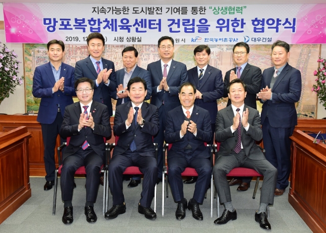 염태영 수원시장(앞줄 왼쪽부터), 김진표 국회의원, 김인식 한국농어촌공사 사장, 백정완 대우건설 주택건축사업본부장이 4일 시청 상황실에서 망포6 택지개발사업지구 내 망포체육공원에 복합체육센터 건립을 위한 업무협약을 체결한후 기념촬영을 하고 있다. 수원시 제공 