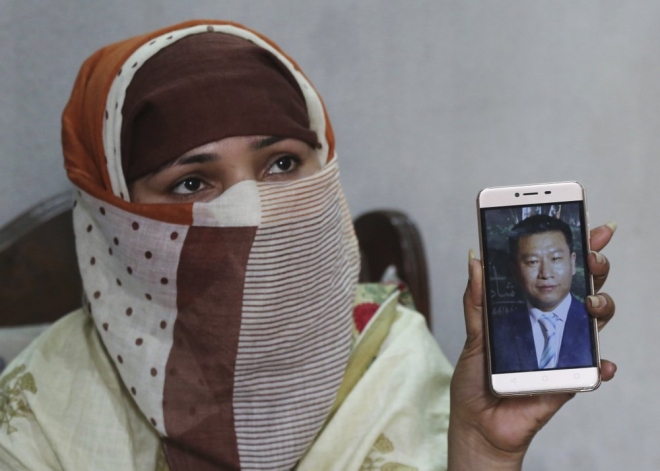 중국 국적의 남성과 결혼했던 한 파키스탄 여성이 휴대폰을 통해 중국인 남편의 사진을 보여주고 있다. 이 여성은 중국으로 가기 전에 이슬라마바드에서 머무는 집에서 중국 남성들에 의해 반복적으로 강간당했다고 주장했다. 사진은 2019년 5월 22일 촬영된 것이다.AP 자료 사진