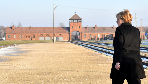 앙겔라 메르켈 독일 총리가 6일 폴란드 아우슈비츠 수용소로 들어가는 기차 트랙 근처를 거닐어 수용소 안으로 걸어 들어가고 있다.오시비엥침 AFP 연합뉴스