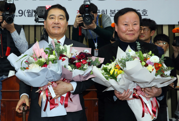 자유한국당 신임 원내대표에 선출된 심재철 의원(왼쪽)과 새 정책위의장에 선출된 김재원 의원이 9일 오전 국회에서 열린 의원총회에서 축하 꽃다발을 받고 기뻐하고 있다. 김명국 선임기자 daunso@seoul.co.kr