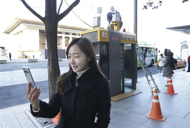11일 서울 광화문 KT 사옥 앞 미세먼지 측정소 앞에서 KT 홍보 모델이 에어맵코리아 앱으로 미세먼지 수치를 확인하고 있다. KT 제공